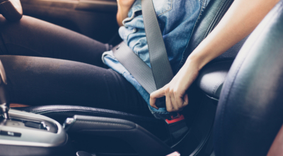woman fastening seat belt in the car