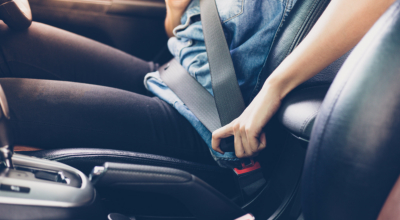 woman fastening seat belt in the car